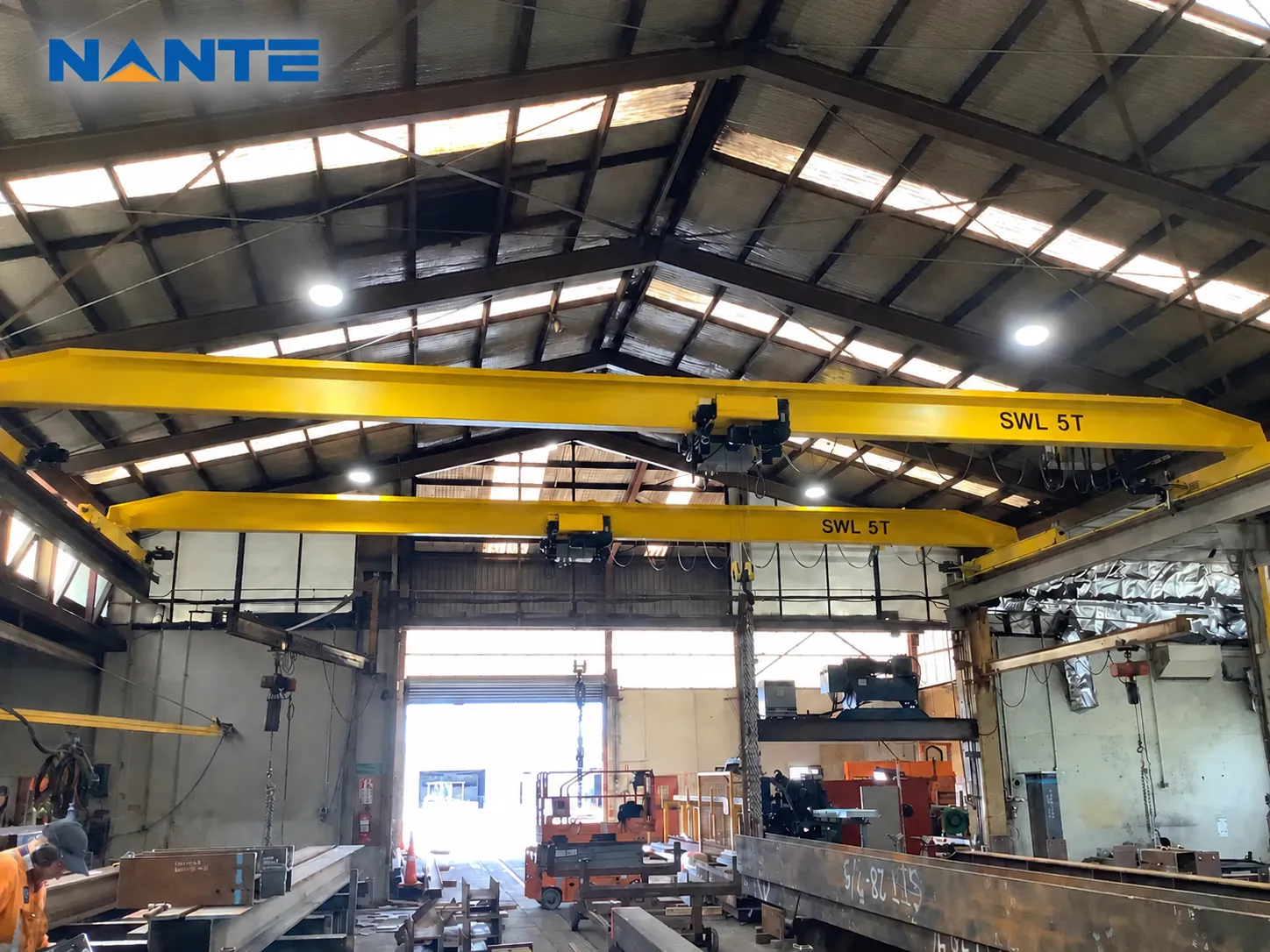 Multiple overhead cranes operating in an industrial workshop