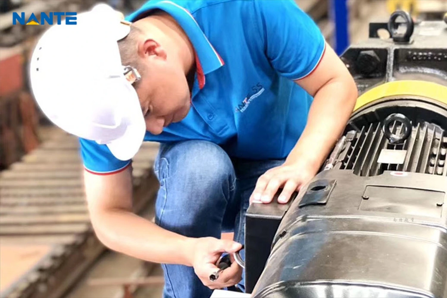 Technician inspecting crane motor and wire rope hoist