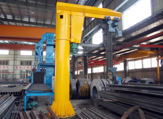 Floor-mounted jib crane installed in a factory, showing the mast base at floor level
