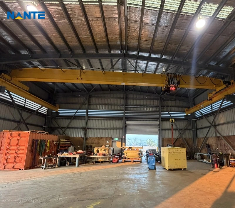 Yellow single girder overhead crane installed inside an industrial workshop