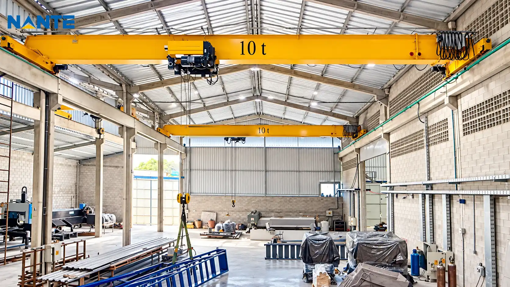 Yellow single girder overhead cranes installed in a factory workshop